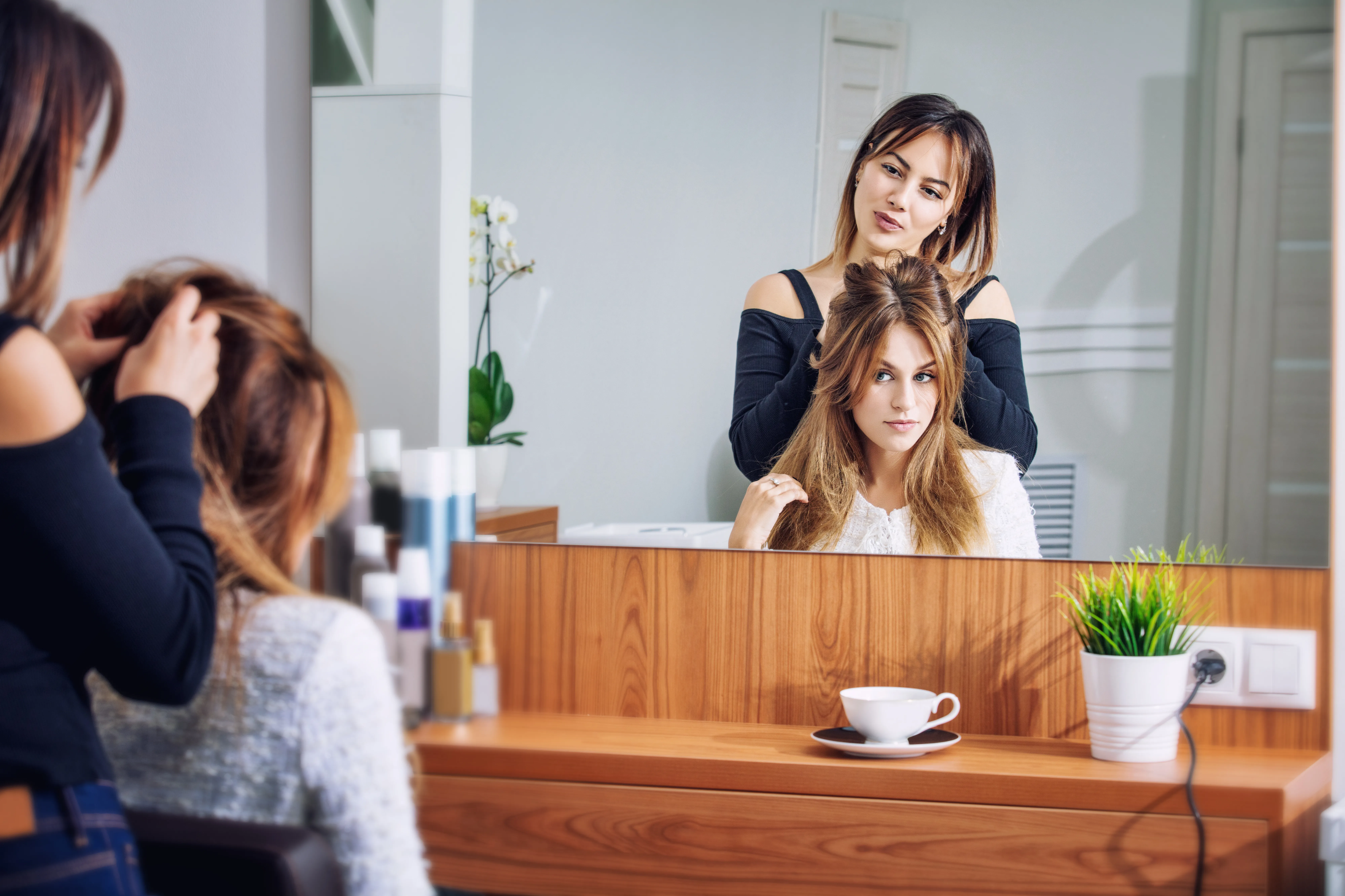 Frau wird von Friseurin beraten